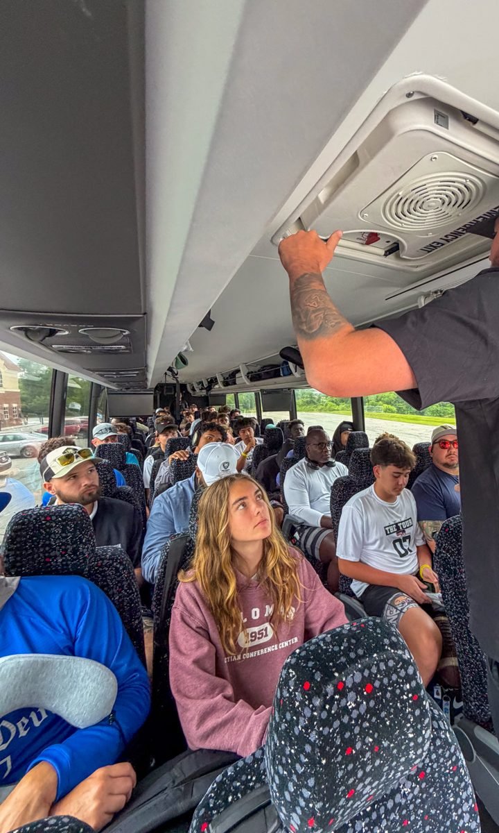 Kennedy Ford seated among the boys on The QB Mag TOUR bus during a staff briefing